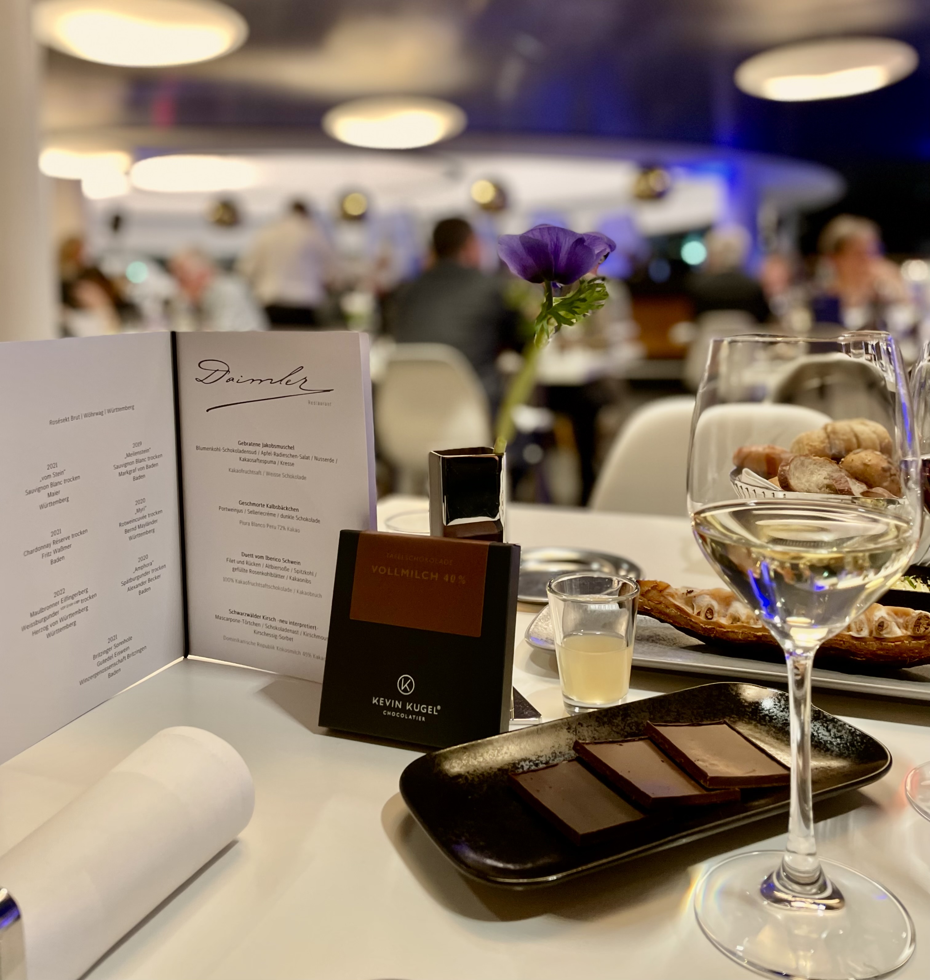 Gedeckter Tisch auf einem Wein und SChokolade Event mit einer Plättchen-auswahl, Wein und Menükarte