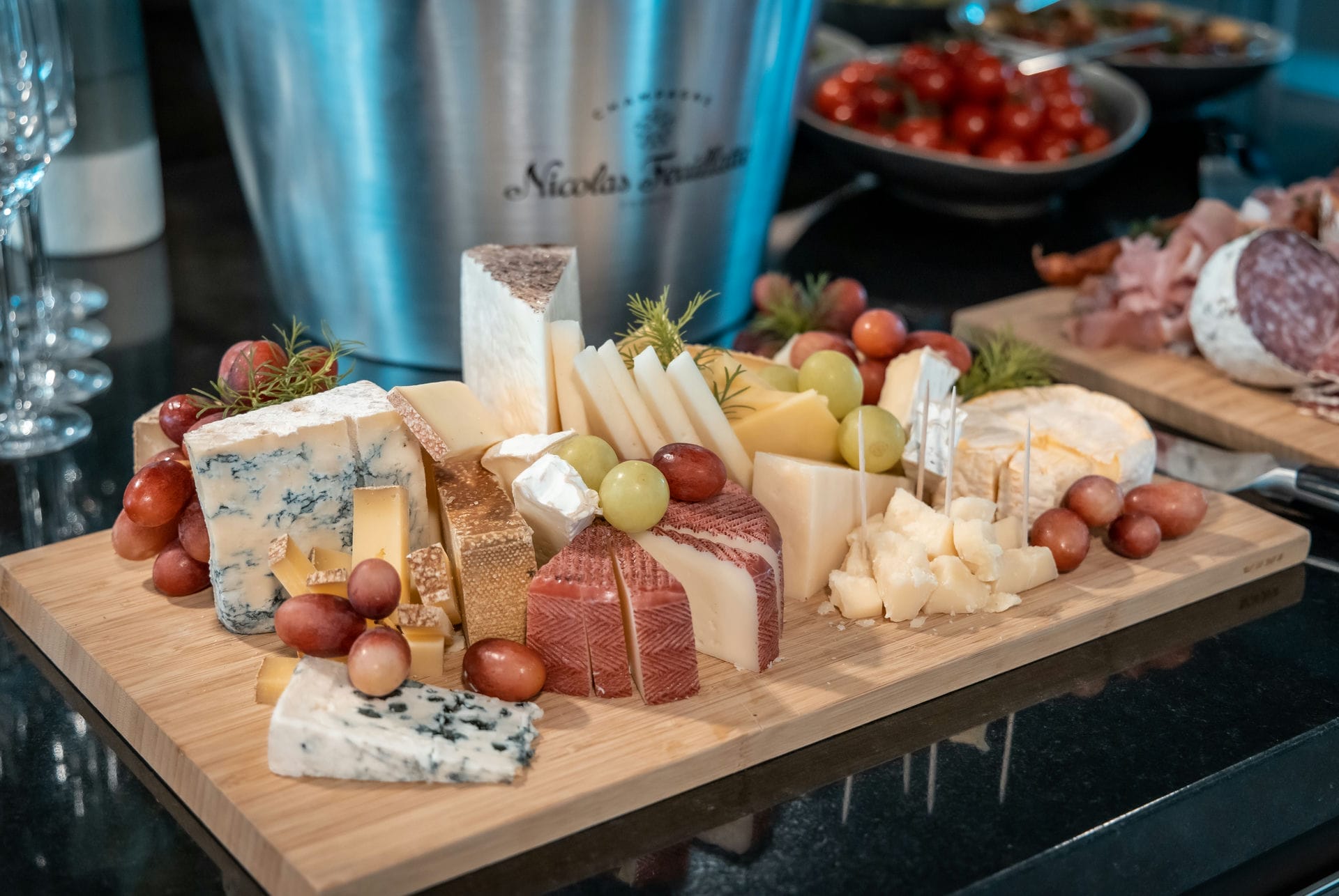 Ein teil des Mediterranen Buffets, Käsevariation und Trauben auf einem großen Holzbrett serviert.
